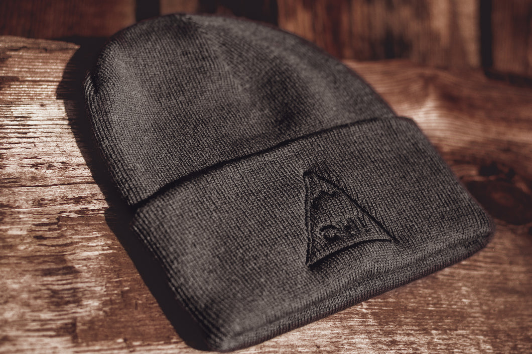 Angled view of Grey Beanie with black embroidered triangle logo and OH! lettering in the centre