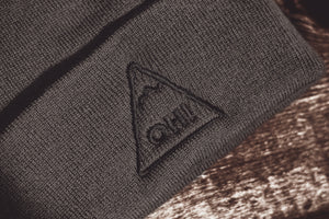 Close up Grey Beanie with black embroidered triangle logo and OH! lettering in the centre