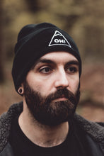 Bearded Model wearing back Beanie with white embroidered triangle and OH! lettering in the centre