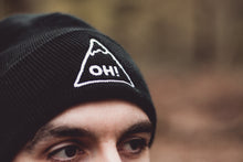 Close up model wearing Black Beanie with triangle logo and OH! embroidered in the centre